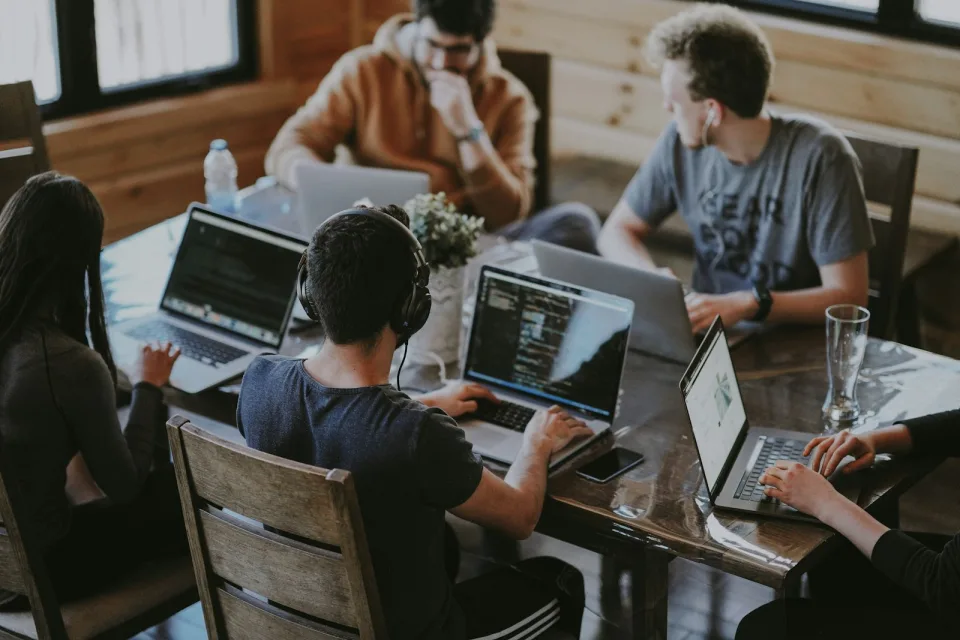 Developers working together on laptops at a shared table